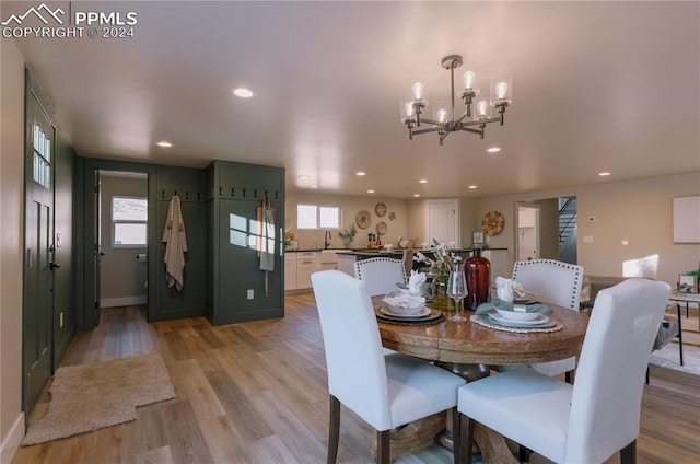 dining room with light hardwood / wood-style flooring, a chandelier, and sink