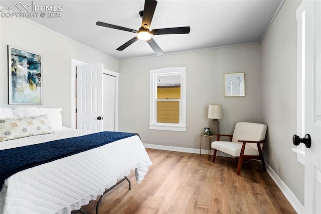 bedroom with hardwood / wood-style floors, a closet, ceiling fan, and crown molding