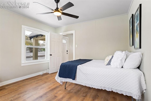 bedroom featuring ceiling fan, wood-type flooring, and crown molding