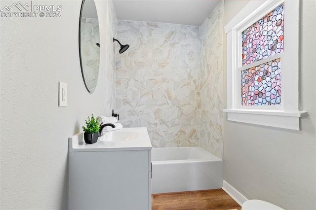 bathroom with vanity, wood-type flooring, and tiled shower / bath