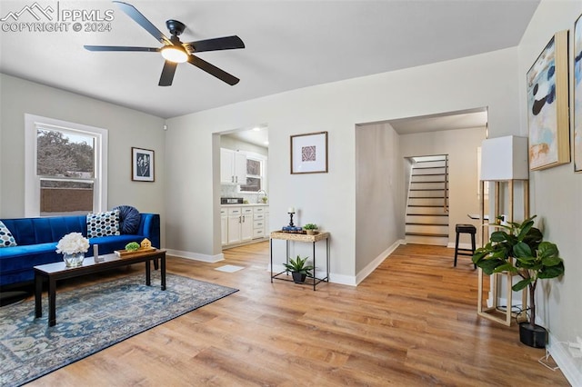 living room with ceiling fan and light hardwood / wood-style flooring