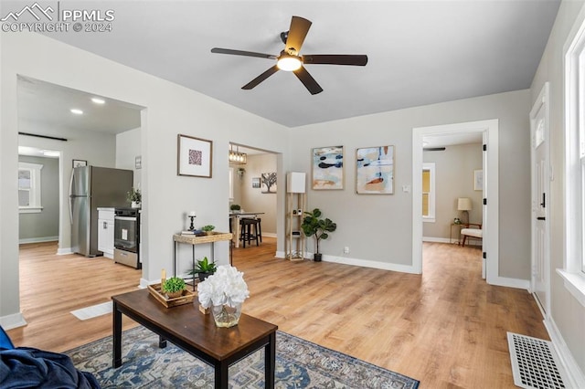 living room featuring ceiling fan and light hardwood / wood-style flooring