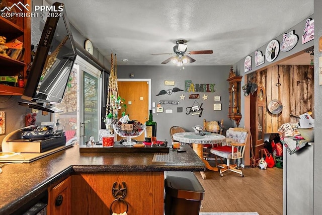 kitchen with ceiling fan, light hardwood / wood-style floors, and a textured ceiling