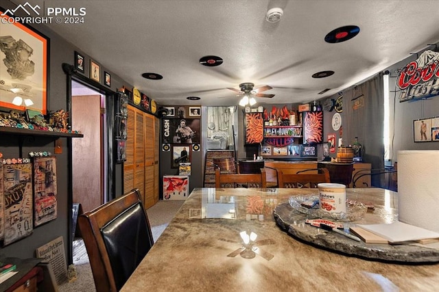 dining room with carpet, ceiling fan, and a textured ceiling