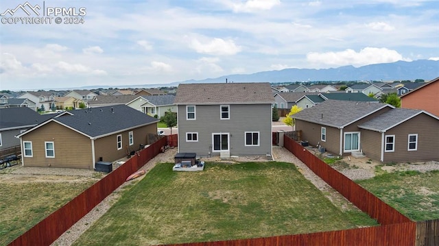 back of house featuring a lawn and a mountain view