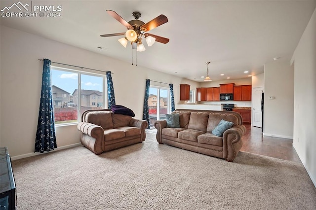 living room with a wealth of natural light, ceiling fan, and dark hardwood / wood-style floors