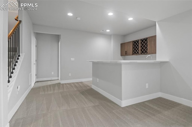 bar featuring light colored carpet and sink