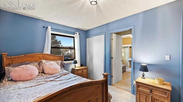 carpeted bedroom with a closet and a textured ceiling