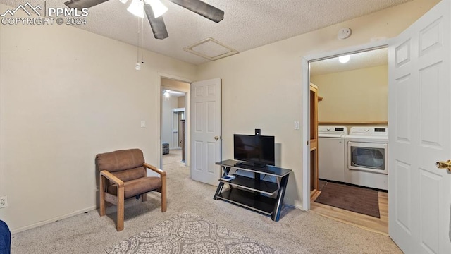 sitting room with light carpet, a textured ceiling, washer and dryer, and ceiling fan