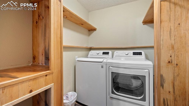 laundry room with washing machine and dryer and a textured ceiling