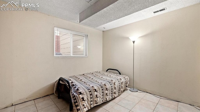 bedroom featuring a textured ceiling and light tile patterned flooring