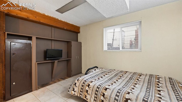 tiled bedroom with a textured ceiling and ceiling fan