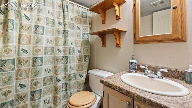 bathroom with walk in shower, vanity, and toilet