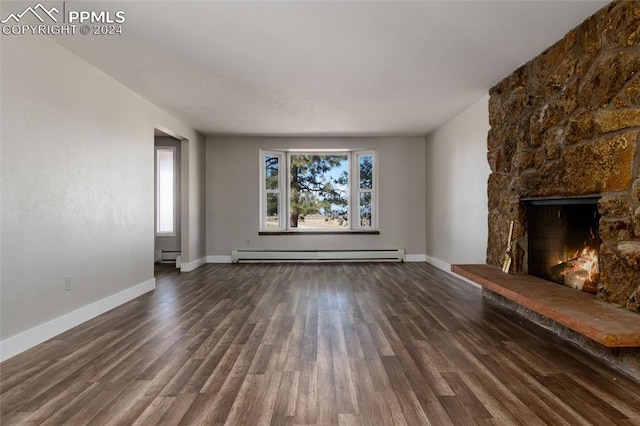 unfurnished living room featuring baseboard heating, a fireplace, and dark wood-type flooring