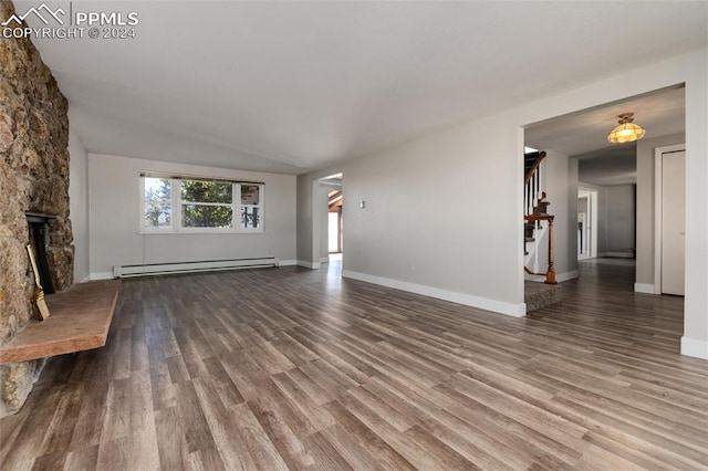 unfurnished living room featuring a baseboard heating unit, a fireplace, lofted ceiling, and hardwood / wood-style flooring