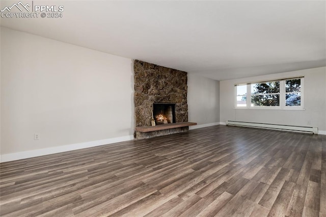 unfurnished living room featuring a fireplace, wood-type flooring, and a baseboard radiator