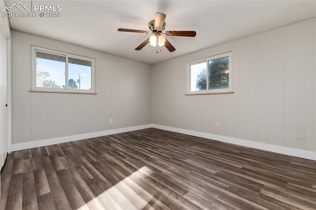 spare room with dark wood-type flooring and ceiling fan