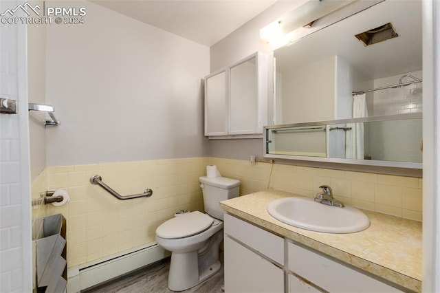 bathroom with hardwood / wood-style flooring, walk in shower, baseboard heating, vanity, and toilet