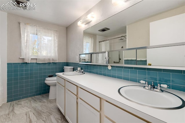 bathroom featuring tile walls, vanity, toilet, and a shower with curtain