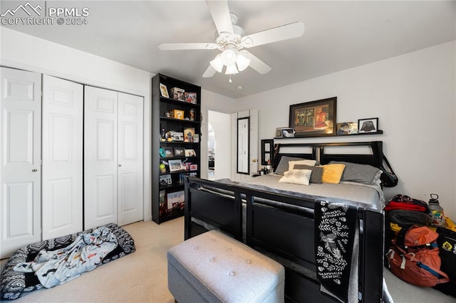 bedroom with ceiling fan, light carpet, and a closet