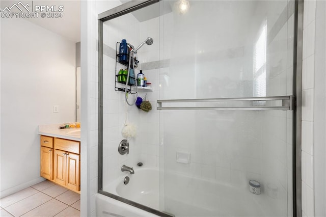 bathroom featuring tile patterned flooring, vanity, and enclosed tub / shower combo