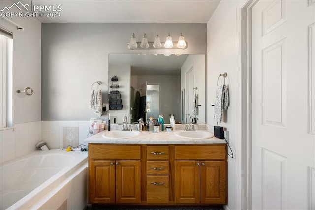 bathroom with vanity and a relaxing tiled tub