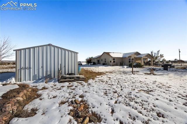 yard covered in snow with an outdoor structure