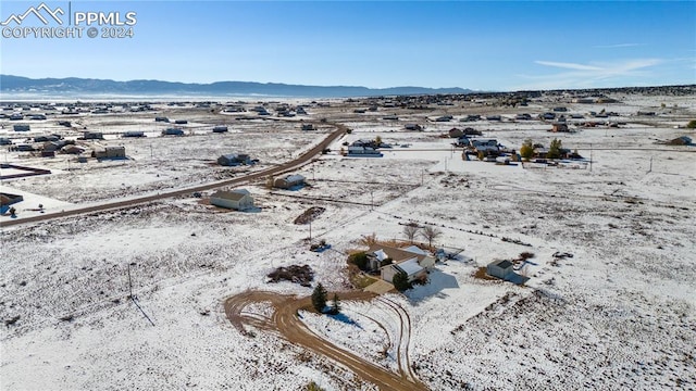 snowy aerial view with a mountain view