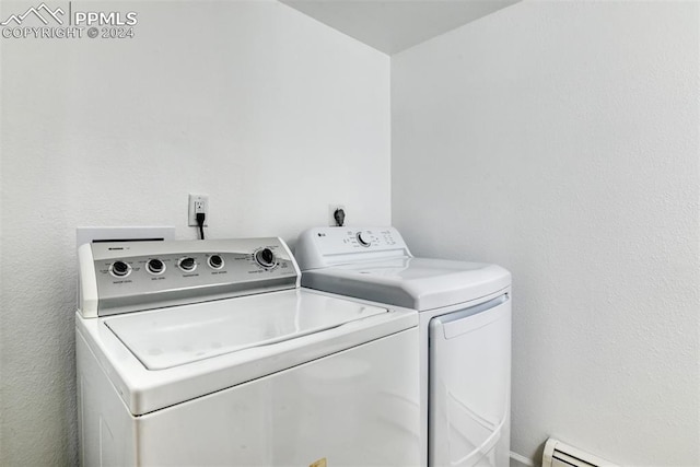 clothes washing area featuring independent washer and dryer and a baseboard radiator