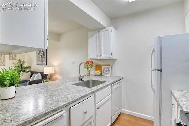 kitchen with white cabinetry, sink, white appliances, and light hardwood / wood-style flooring