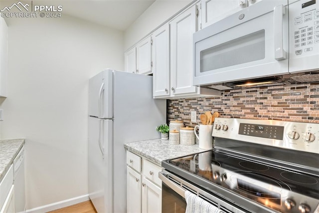 kitchen featuring tasteful backsplash, white cabinetry, light hardwood / wood-style flooring, and white appliances