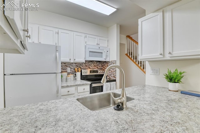 kitchen featuring white cabinetry, white appliances, sink, and tasteful backsplash