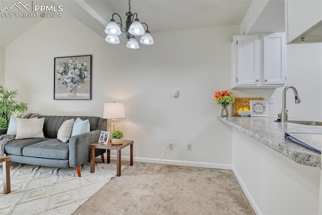 interior space featuring sink, hanging light fixtures, vaulted ceiling, light colored carpet, and white cabinetry