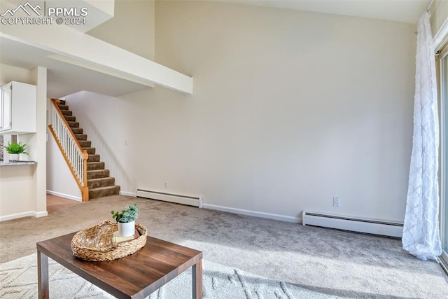 unfurnished living room with light colored carpet and baseboard heating