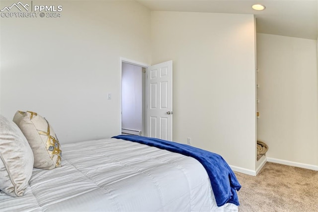 carpeted bedroom with baseboard heating and high vaulted ceiling