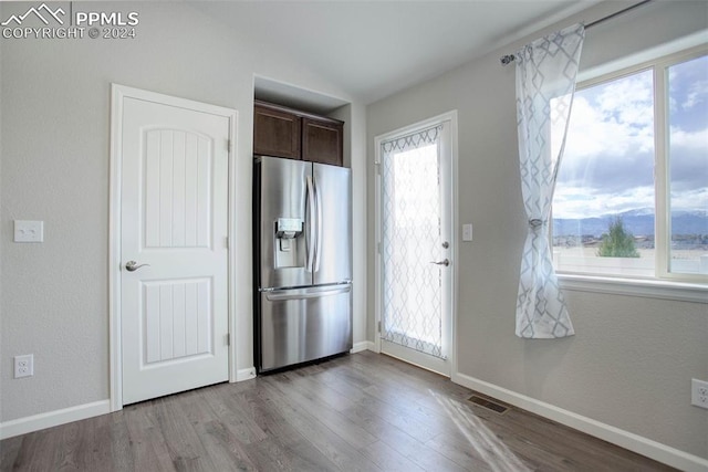 kitchen featuring light wood-type flooring, stainless steel refrigerator with ice dispenser, and dark brown cabinetry