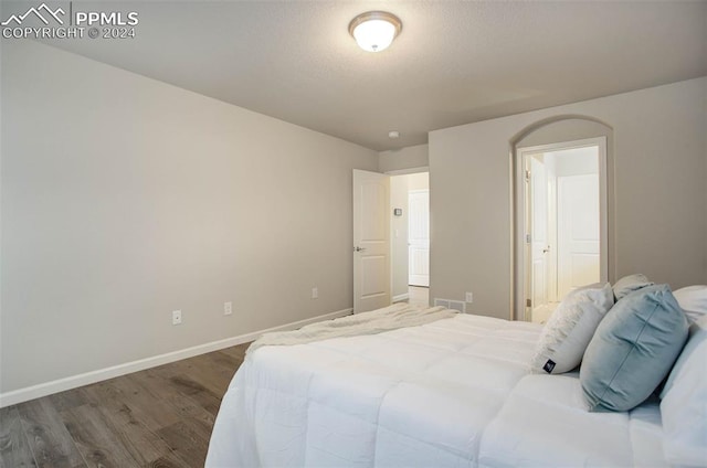 bedroom with dark hardwood / wood-style flooring