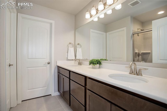 bathroom featuring walk in shower, vanity, and tile patterned flooring