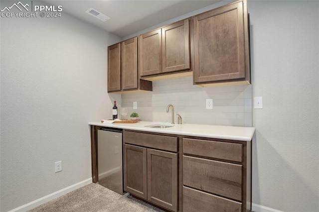 kitchen featuring tasteful backsplash, sink, light carpet, and stainless steel fridge