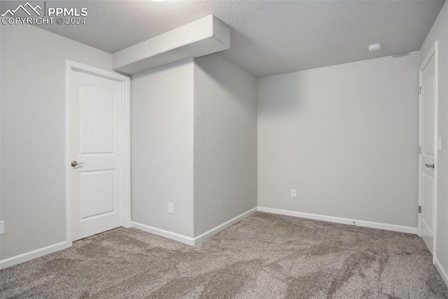 carpeted empty room featuring a textured ceiling