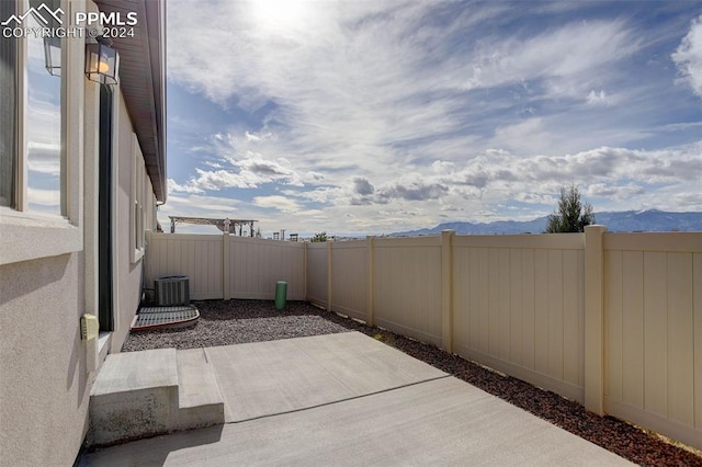 view of patio / terrace featuring a mountain view and central AC unit