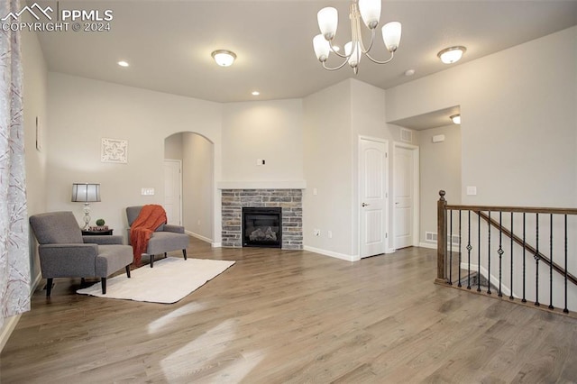 living area featuring a fireplace, hardwood / wood-style flooring, and an inviting chandelier