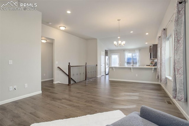 living room featuring dark hardwood / wood-style flooring and an inviting chandelier