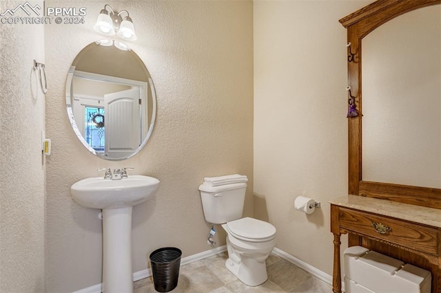 bathroom featuring toilet, sink, and tile patterned floors