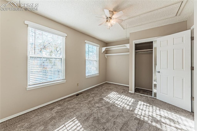 unfurnished bedroom with ceiling fan, carpet floors, and a textured ceiling