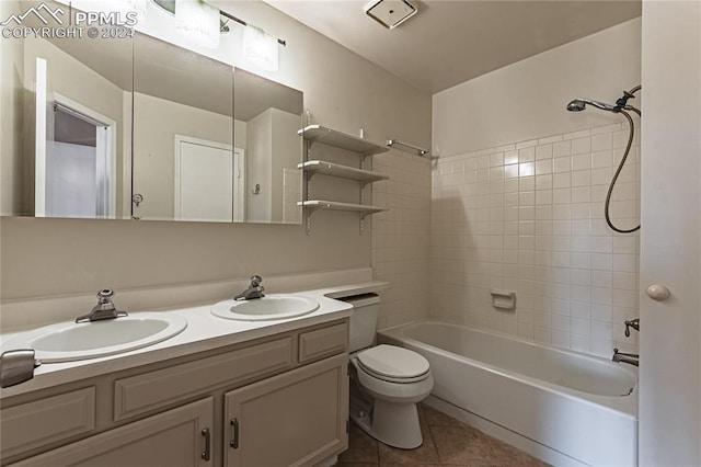 full bathroom featuring tile patterned flooring, vanity, tiled shower / bath combo, and toilet