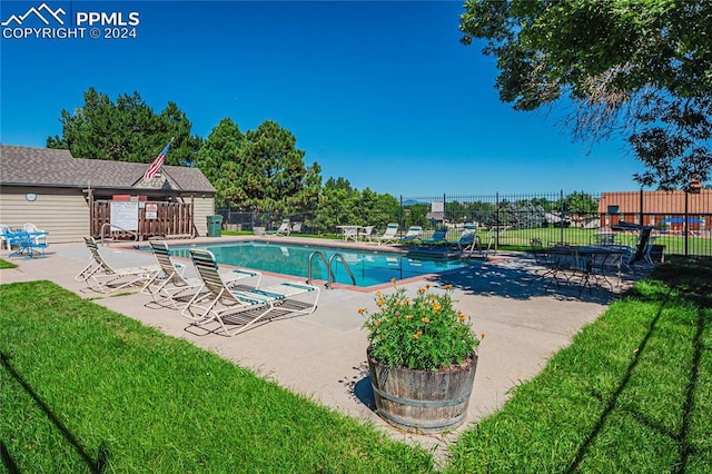 view of swimming pool featuring a lawn and a patio