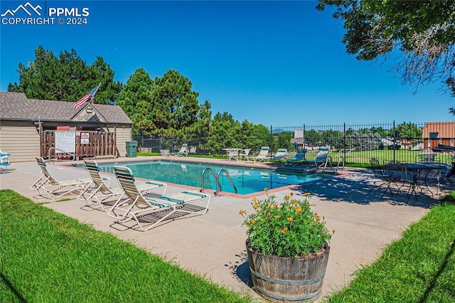 view of pool with a patio area and a lawn