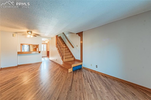 unfurnished living room featuring a textured ceiling, hardwood / wood-style flooring, and ceiling fan