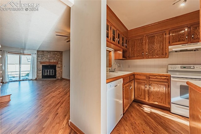 kitchen featuring a fireplace, white appliances, sink, and light hardwood / wood-style flooring